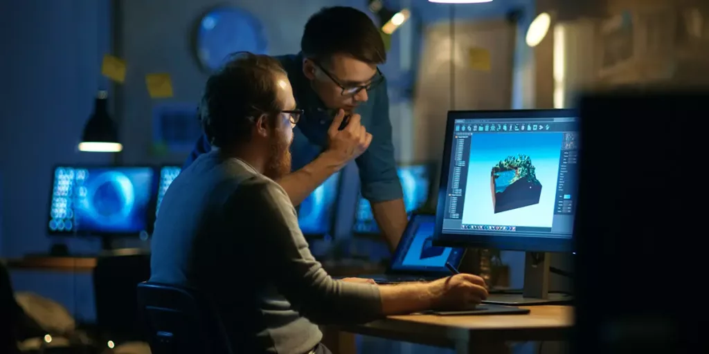 desenvolvedor de jogos sentado a frente de computador com modelagem 3D na tela utilizando mesa digitalizadora